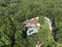 Expansive home in a private, wooded setting featuring an in-ground pool and a long, private driveway at 3355 Old Peachtree Rd, Dacula, GA 30019