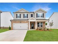 Charming two-story home with stone accents, attached garage, and a beautifully manicured lawn at 722 Crossroad Ct, Powder Springs, GA 30127