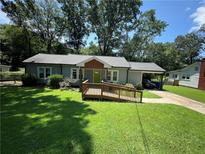 Charming single-story home with a lush green lawn and convenient carport at 1482 Whitfield Se St, Smyrna, GA 30080