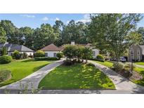 Well maintained front yard with a circular driveway and mature trees at 2050 Trotters Ridge Way, Roswell, GA 30075