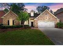 Charming brick home featuring a well-manicured lawn and a two-car garage in a desirable neighborhood at 1065 Beacon Hill Xing, Alpharetta, GA 30005