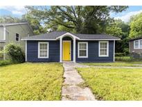 Charming bungalow-style home with a striking yellow front door and well-maintained lawn at 971 Sims Nw Ave, Atlanta, GA 30318