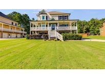 Charming two-story home boasts a covered front porch, lush lawn, and mature landscaping at 27 Riverview Trl, Euharlee, GA 30145