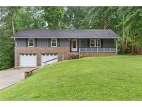 Charming home featuring a brick and siding exterior, a well-manicured lawn, and an attached two-car garage at 3105 Sumac Dr, Atlanta, GA 30360