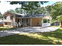 Tan split-level home featuring a covered carport and front porch at 1041 Waverly Drive Dr, Lawrenceville, GA 30046