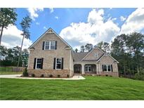 Charming brick home featuring a manicured lawn and classic architectural details at 7791 Capps Ridge Ln, Douglasville, GA 30135