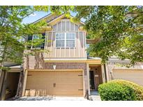 Charming two-story townhouse with a brick facade, attached garage, and mature landscaping at 3832 Augustine Pl, Rex, GA 30273