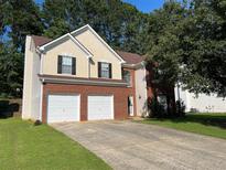 Two-story home with a brick facade, attached two-car garage, and driveway at 455 Crafton Ct, Lawrenceville, GA 30043