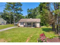 Charming single-story home featuring a covered porch and a lush, well-maintained front yard at 2560 Fairlane Dr, Cumming, GA 30041