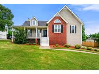 Charming two-story home with a brick accent, manicured lawn, and a welcoming porch, perfect for relaxing outdoors at 71 Barrington Dr, Hiram, GA 30141