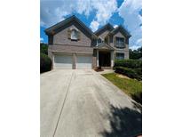 Charming two-story brick home with a two-car garage and well-maintained front yard at 6398 Foggy Oak Dr, Fairburn, GA 30213
