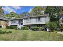 Charming split-level home featuring gray siding, manicured landscaping, and a well-maintained front yard at 4187 Alaina Cir, Austell, GA 30106