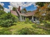 Charming two-story home with a gabled roof, brick chimney, and lush landscaping in a suburban setting at 222 Winonna Dr, Decatur, GA 30030