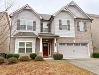 Charming two-story home featuring a gray exterior, brick accents, attached two-car garage and manicured landscaping at 1264 Brynhill Ct, Buford, GA 30518