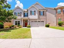 Charming two-story home with manicured lawn, brick accents, and a spacious two-car garage at 1264 Brynhill Ct, Buford, GA 30518