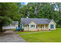 Charming single-story home with a well-maintained lawn, complemented by a detached garage and driveway at 4030 Grady Smith Road Rd, Loganville, GA 30052