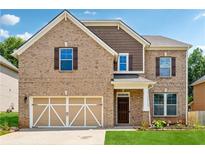 Inviting two-story brick home with a two-car garage and manicured lawn at 5430 Breckinridge Ln, Cumming, GA 30040