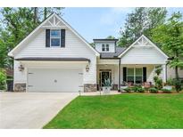 Charming home featuring a well-maintained lawn, stone accents, and an inviting covered front porch at 5015 Monticello Dr, Villa Rica, GA 30180
