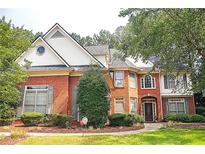 Beautiful brick two-story home with a manicured lawn and mature trees at 555 Stoneglen Sw, Atlanta, GA 30331