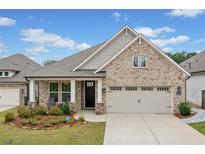 Charming brick home with a two-car garage, landscaped yard, and inviting front porch at 205 Floral Valley Dr, Woodstock, GA 30188