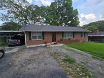 Charming one-story brick home with green shutters, well-manicured lawn and a convenient carport at 1763 Sandtown Sw Rd, Marietta, GA 30060