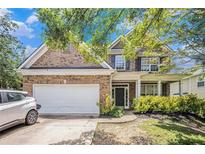 Charming two-story brick home featuring a two-car garage and a welcoming front porch at 485 Greyhawk Way, Fairburn, GA 30213
