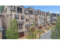 Beautiful townhomes showcasing brick facade, private garages, and well-maintained landscaping at 3450 Commander Cv, Suwanee, GA 30024