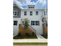 Charming townhome with a painted brick facade and a wooden porch with stairs and black railings at 1583 Salem Dr # 79, Conyers, GA 30013