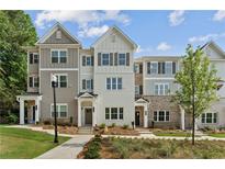 New townhouse exteriors showing a brick and siding facade with manicured lawns at 1995 Deco Dr, Kennesaw, GA 30144