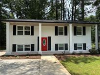 Charming two-story home with white brick, black shutters, and a vibrant red front door at 2764 Ocean Valley Dr, Atlanta, GA 30349