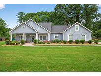Charming single-story home with a well-manicured lawn, tidy bushes, and welcoming front porch at 905 S Cherokee Rd, Social Circle, GA 30025