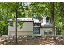 Charming two-story home with blue double door entry and natural wooded surrounding at 671 Lost Creek Cir, Stone Mountain, GA 30088