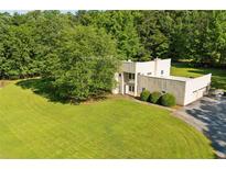 Unique home boasting a lush green lawn, mature trees, and a multi-car garage at 110 Bridger Point Rd, Fayetteville, GA 30215
