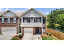 Charming two-story townhome features a well-kept front yard and a one-car garage at 173 Oakland Hills Way, Lawrenceville, GA 30044