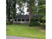 Charming single-story home featuring a cozy covered porch and a lush green front lawn at 2591 Perkerson Dr, Austell, GA 30168