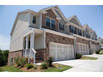 Charming townhome featuring a brick facade and a two-car garage at 339 Cherryhill Ln, Woodstock, GA 30188