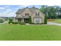 Charming two-story home featuring a well-manicured lawn and beautifully landscaped front yard at 108 Donovan Ave, Locust Grove, GA 30248