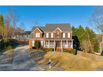 Inviting two-story brick home with a charming front porch and well-manicured landscaping at 4055 Inman Park Ln, Buford, GA 30519