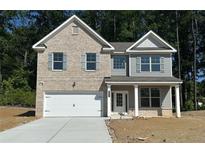 Charming two-story home with brick and siding, complemented by blue shutters and a two-car garage at 525 Paces Dr, Lithia Springs, GA 30122