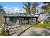 Charming home with a covered porch, dark painted brick, modern railings, and a driveway at 1505 Ezra Church Nw Dr, Atlanta, GA 30314