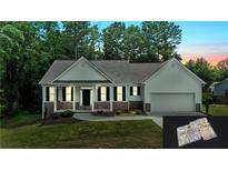 Charming single-story home with white siding, stone accents, well-maintained lawn and attached two car garage at 504 Iris Way, Villa Rica, GA 30180
