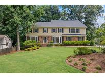 Charming two-story home with a well-manicured lawn, mature trees, and lush landscaping at 1416 Vernon Ridge Close, Dunwoody, GA 30338