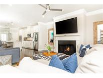 Bright living room features a fireplace, TV, ceiling fan, and connects to a modern kitchen at 3133 Quinn Pl, Atlanta, GA 30341