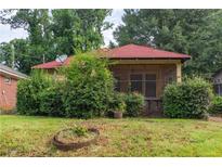 Charming single-story home with a red roof, screened front porch, and mature landscaping at 969 Byron Sw Dr, Atlanta, GA 30310
