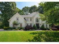 Inviting home featuring a lush green lawn, mature landscaping, and an elegant facade with a welcoming entrance at 10650 Centennial Dr, Alpharetta, GA 30022
