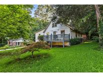 Charming house with a deck and lush green lawn surrounded by mature trees at 6719 Sunset Valley Cir, Rex, GA 30273