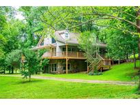 Beautiful home exterior with large deck and lush green lawn, surrounded by mature trees at 1775 Whooping Creek Rd, Carrollton, GA 30116