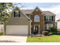 Charming two-story home boasts a blend of brick and siding, a well-manicured lawn, and a two-car garage at 2251 Fall Creek Lndg, Loganville, GA 30052
