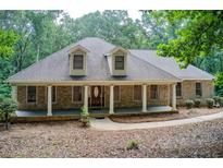 Charming brick home featuring a welcoming front porch with stately columns and a well-maintained lawn at 155 Skyview Dr, Social Circle, GA 30025