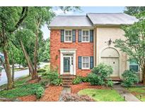 Charming townhome featuring brick facade, complemented by mature landscaping and a welcoming entrance at 2197 Spring Walk Ct, Atlanta, GA 30341
